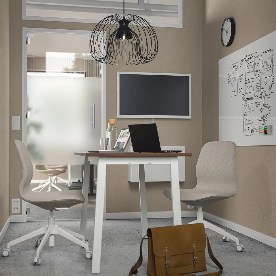 Modern office with MITTZON table, chairs, and screen. Table has walnut top and steel legs with hooks.
