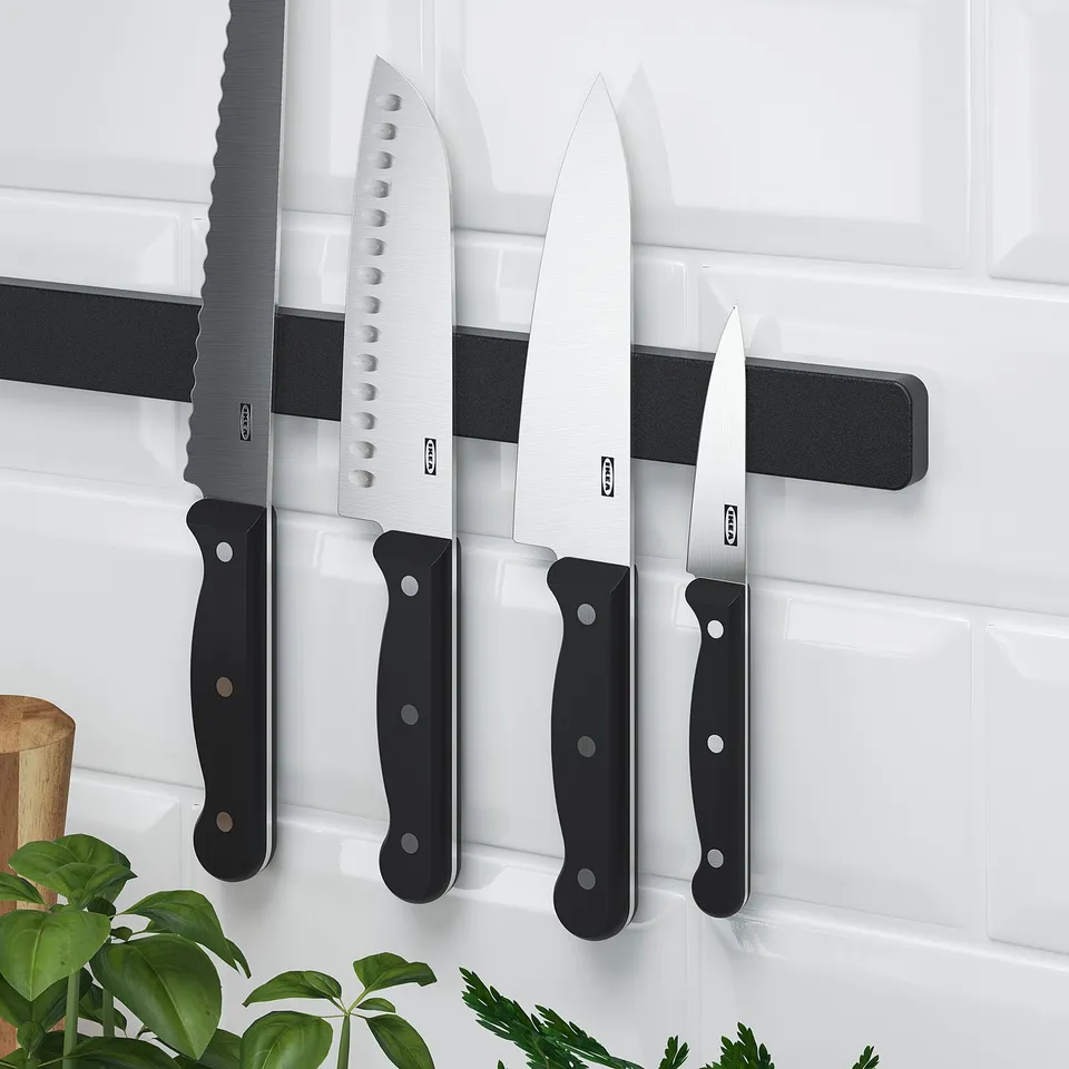 Magnetic knife rack on wall with four knives. HULTARP series, organises and protects knives.