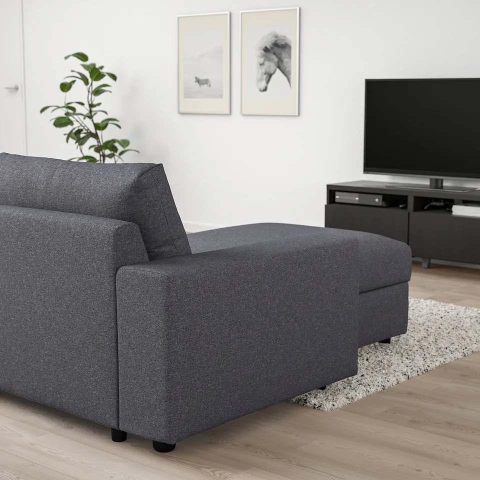 Modern living room with grey VIMLE sectional sofa, tv, rug, plant, and artwork.