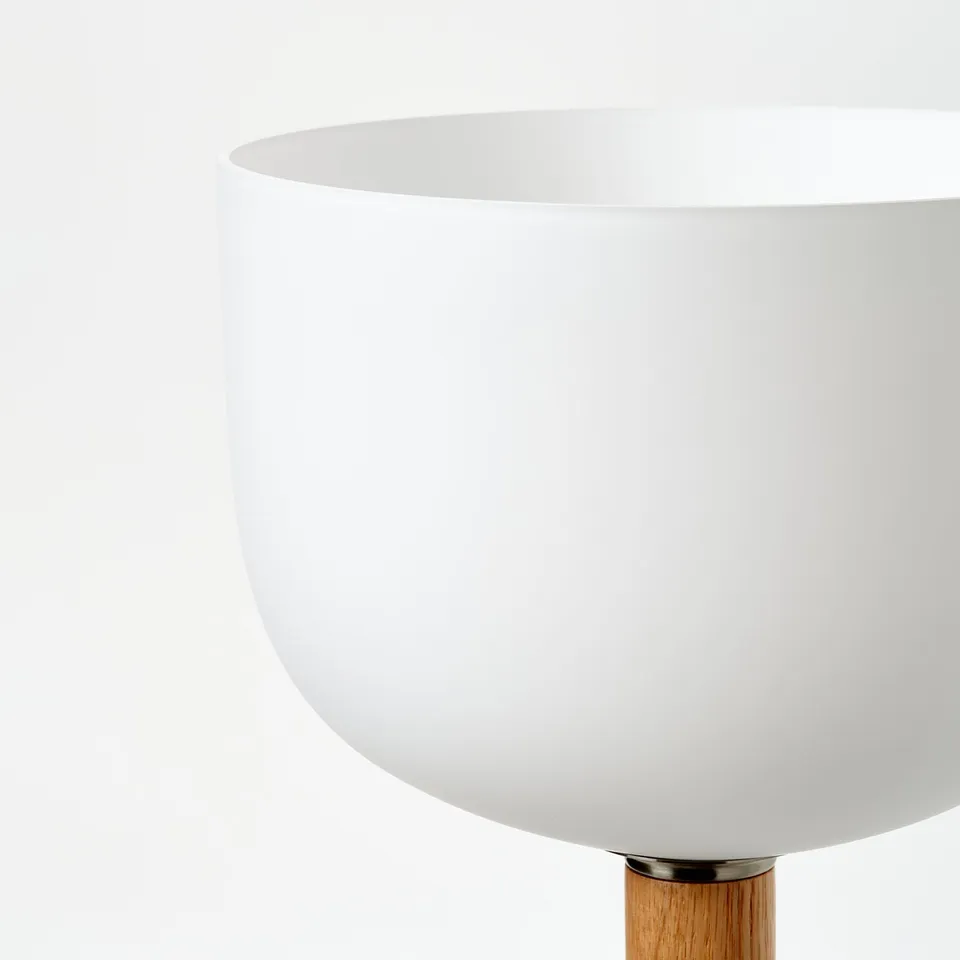 Modern floor lamp with sleek white shade and wooden base, emitting a minimalist and clean aesthetic.