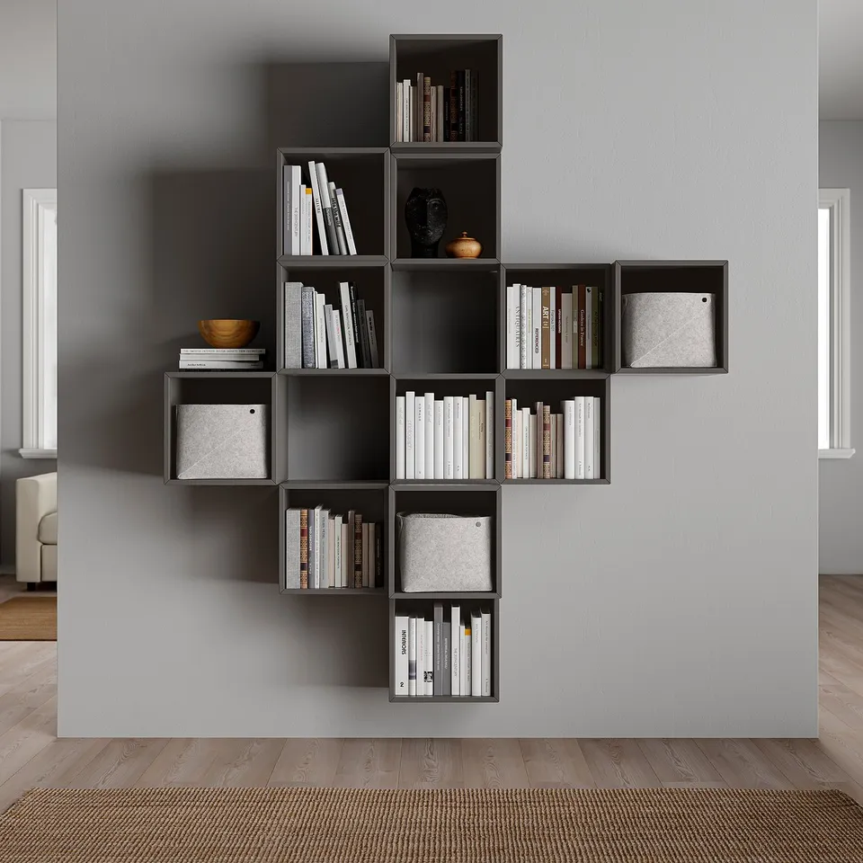 Modern, grey, modular bookshelf with boxes and books, mounted on a grey wall.