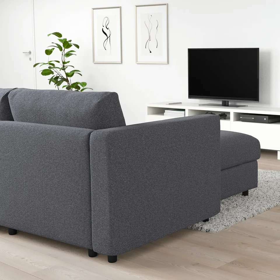 Modern living room with large grey VIMLE sectional sofa, flat-screen tv on stand, abstract wall art, and floor plant.
