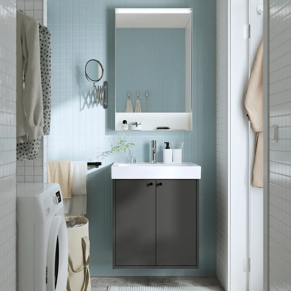Modern bathroom with HAVBÄCK dark grey vanity, white sink, mirror, and blue tiles.