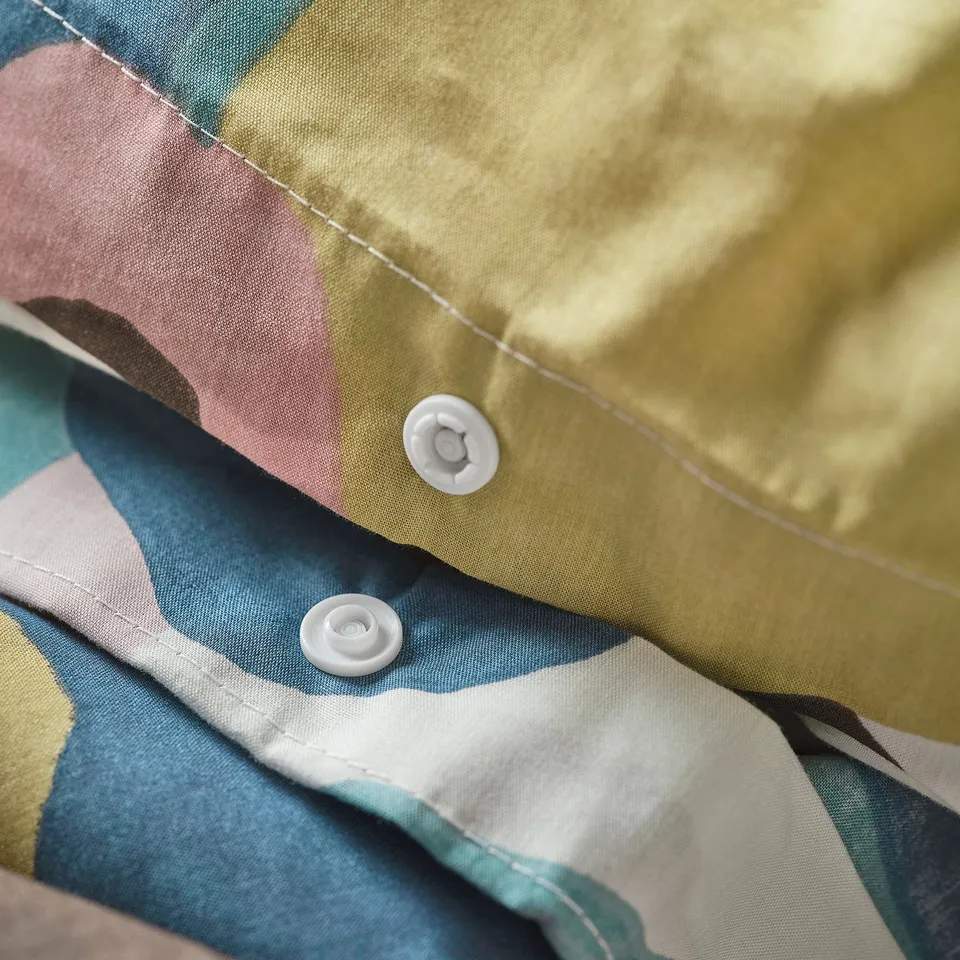 Close-up of a VIDEOXBÄR duvet cover showing two plastic press studs securing the duvet inside.