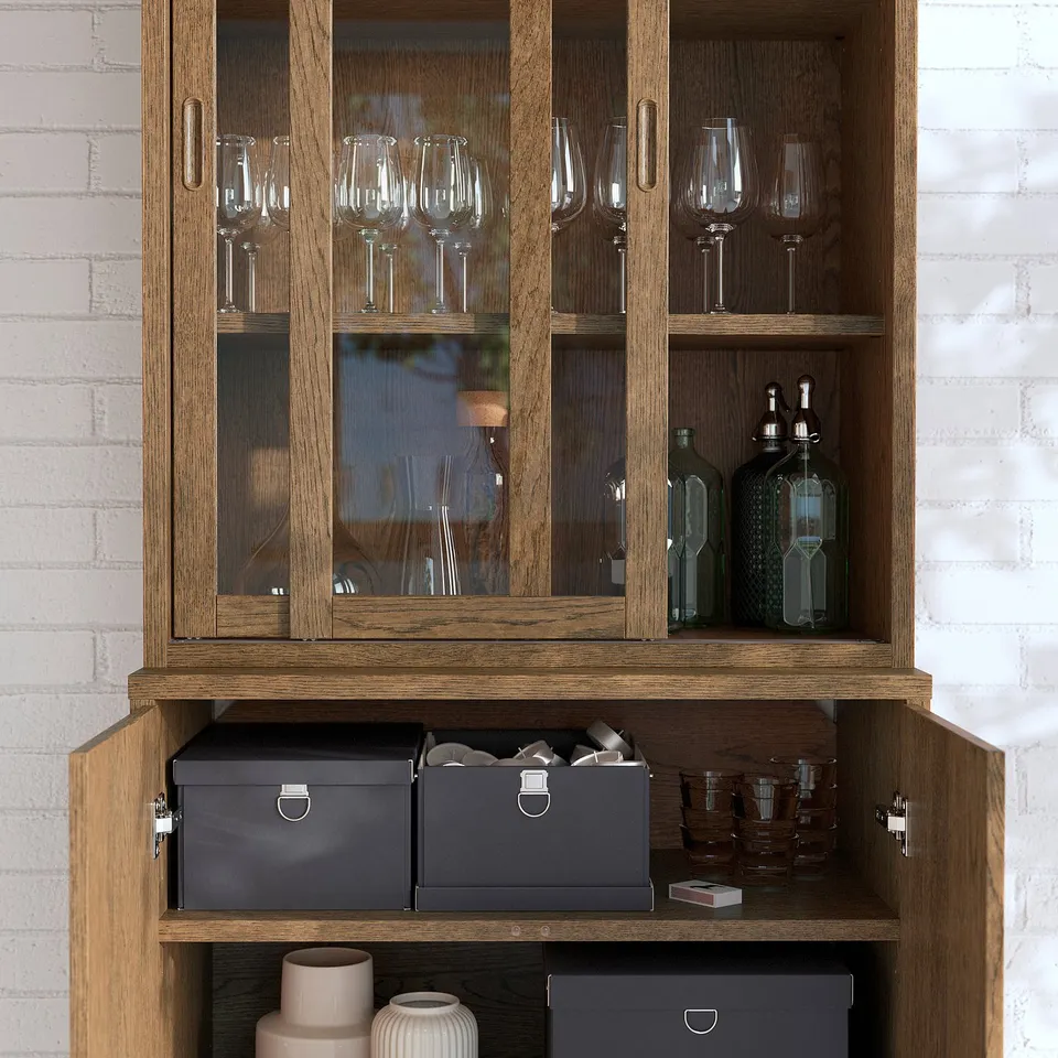 Wooden cabinet with glass doors, showcasing wine glasses and bottles. Soft-close doors and adjustable shelves visible.