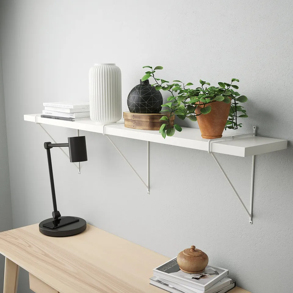 Wooden desk with white shelf holding books, plants, lamp, and magazines.