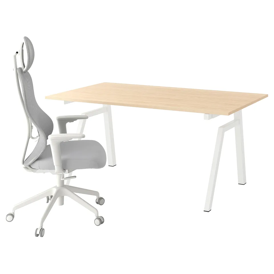 A TROTTEN sit/stand desk and chair. The desk is light wood with white legs. The chair is white with mesh back support.