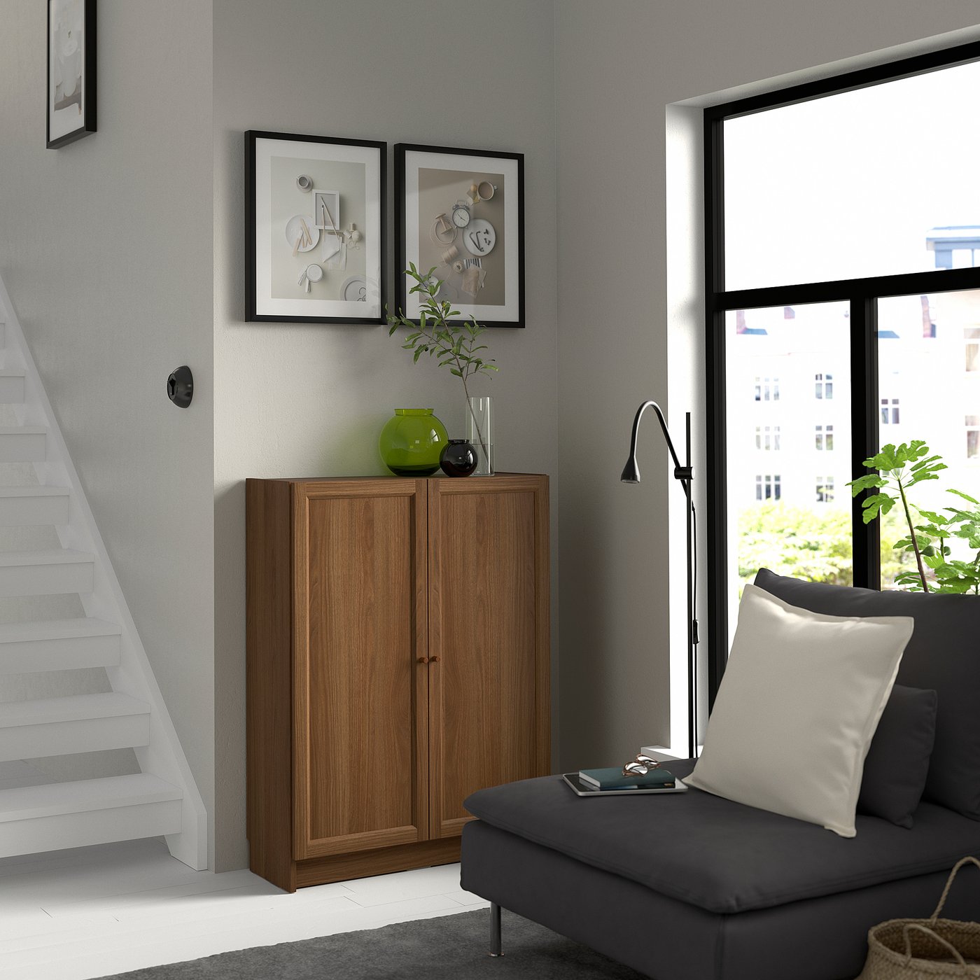Modern living room with BILLY bookcase, grey sofa, and urban view from window.