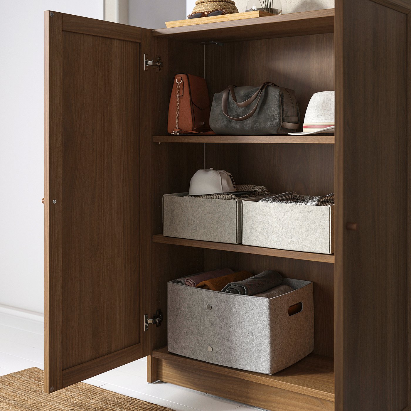 Wooden cabinet with three shelves showing storage of handbags and boxes.