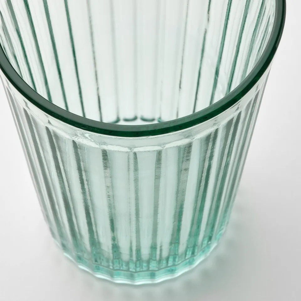 A clear, fluted glass tumbler with a thick base, made of tempered glass. Its design is simple and elegant, ideal for various beverages.