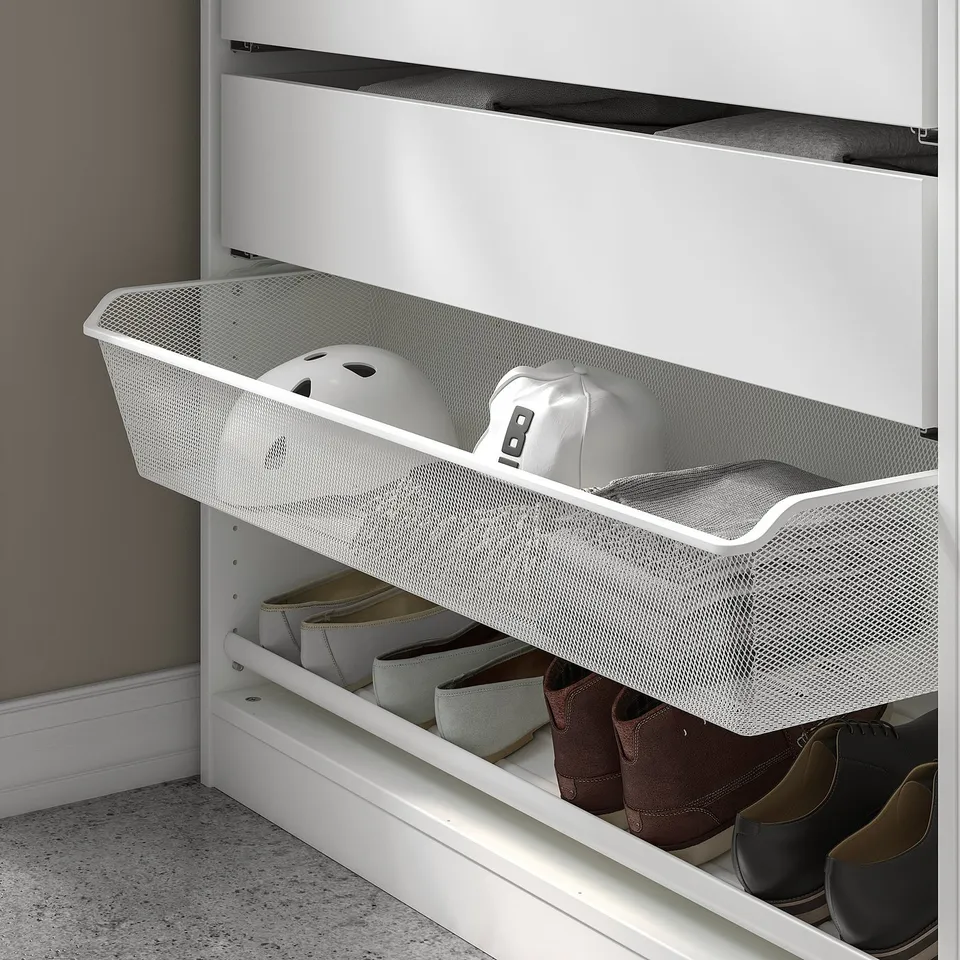 A white KOMPLEMENT mesh basket with items on shelves, allowing air circulation and visibility.