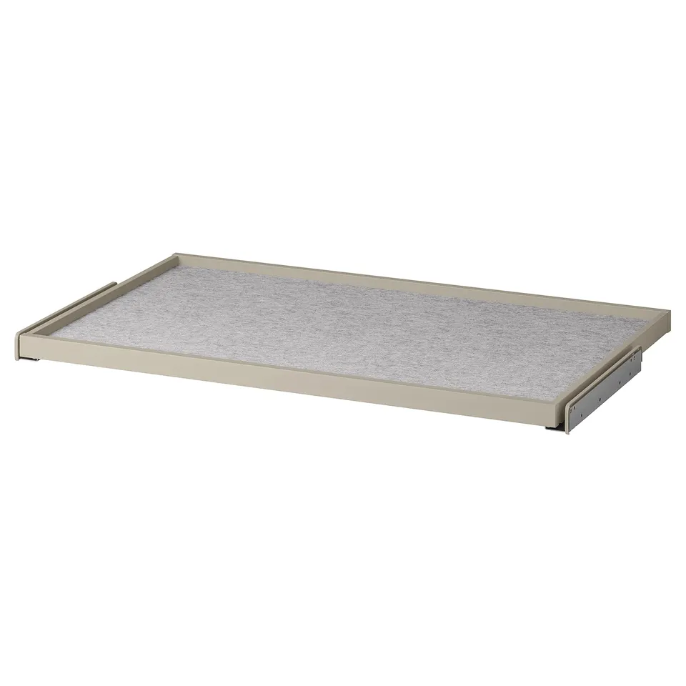 An ikea KOMPLEMENT pull-out tray in beige with a textured white felt mat, designed for organizing wardrobe space.