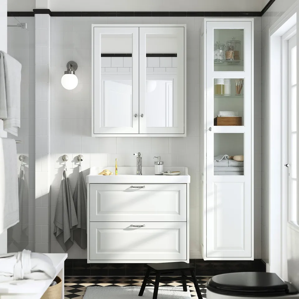 Modern bathroom with high white TÄNNFORSEN cabinet, glass door, chrome hardware, and adjustable shelves.