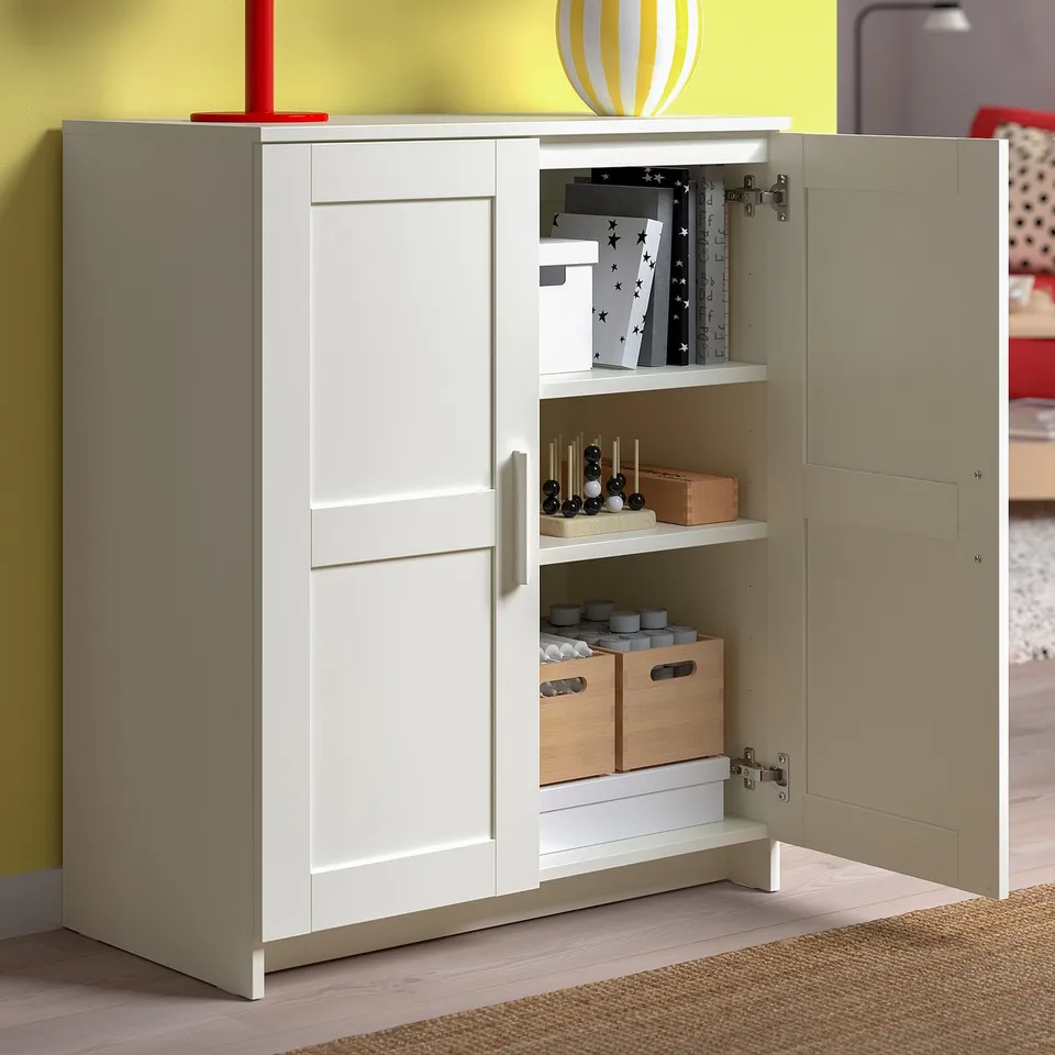 White tv stand with open doors, adjustable shelves, and cable outlets. Stores games, controls, and accessories.