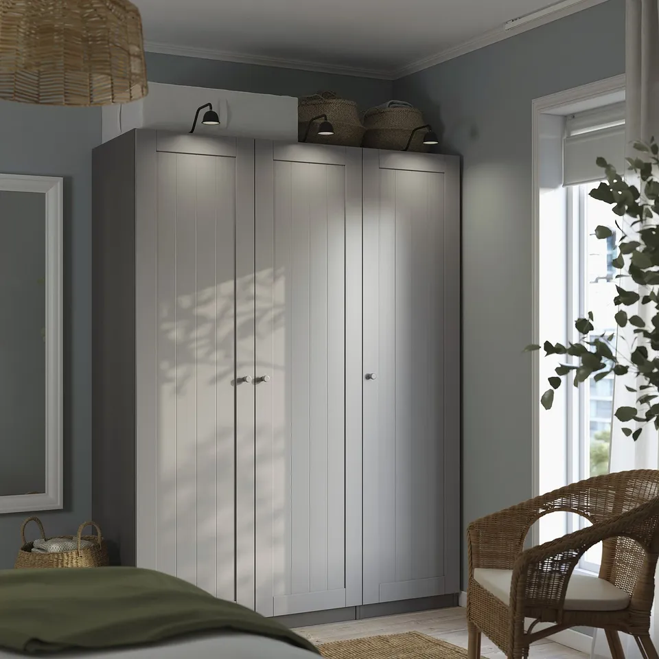 White PAX wardrobe with storage, wicker, lighting, baskets, window, chair.