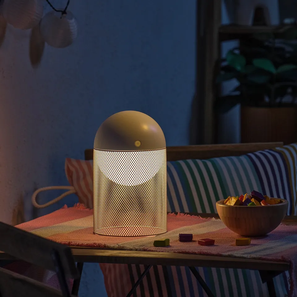 Modern SOLVINDEN lamp on wood table with snacks, indoor/outdoor.