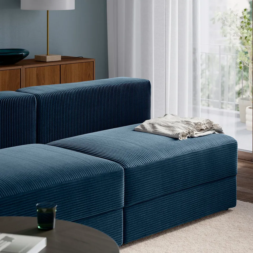 Modern living room with teal JÄTTEBO modular sofa. Blend comfort and style, showcasing adjustable seating.