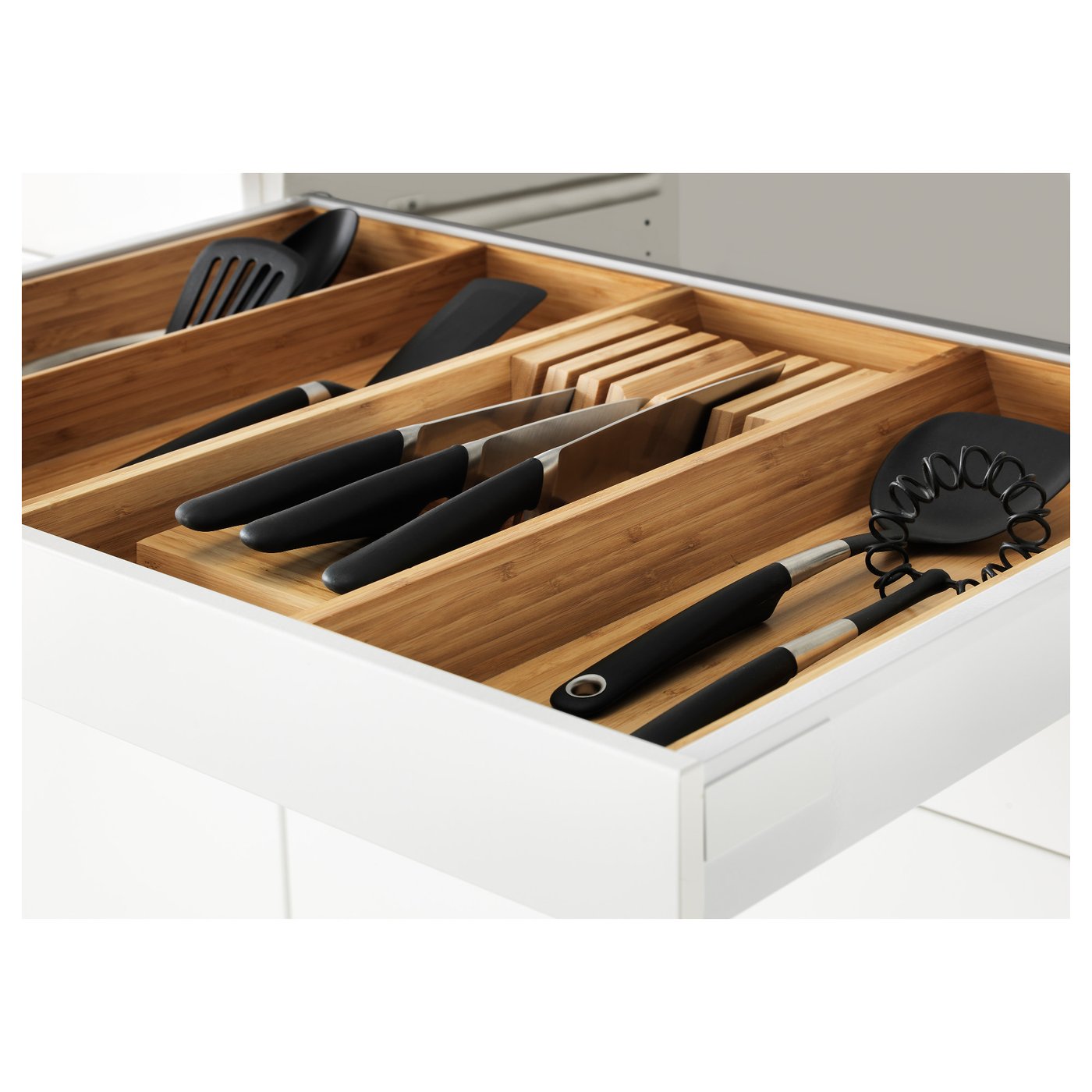 Organised kitchen drawer with wooden separators holding knives and utensils neat and safe.