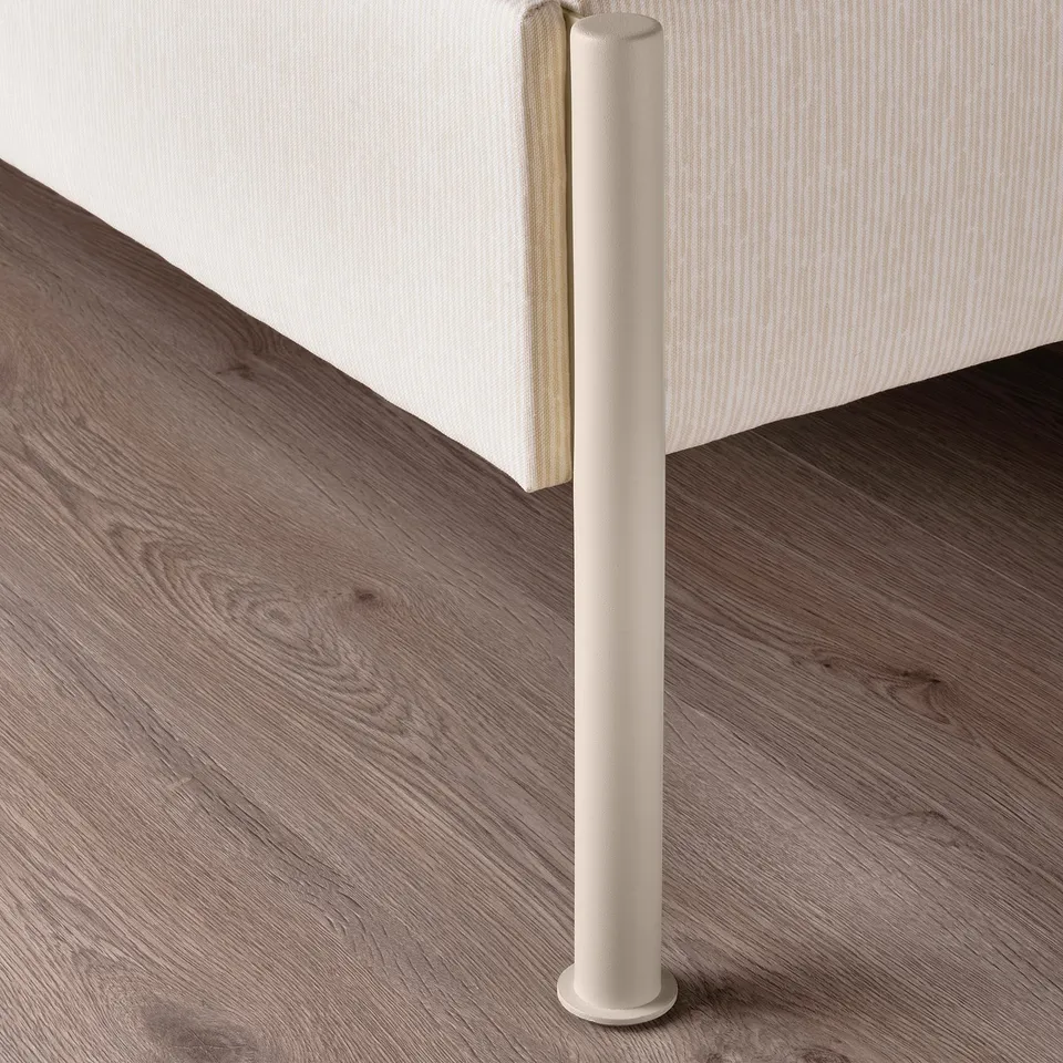 Beige striped bed with metal legs.