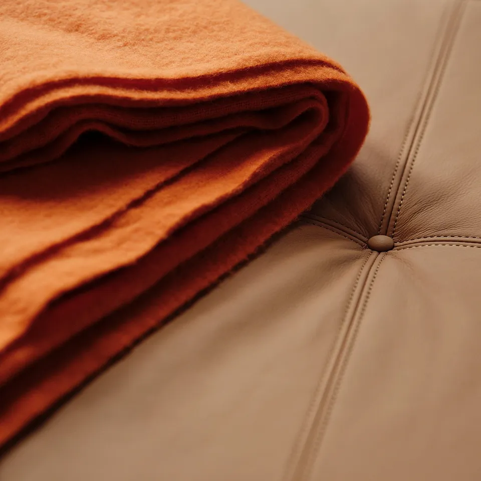 Close-up of luxurious, soft orange leather on modern light wooden bench, showcasing high-quality craftsmanship and comfort.