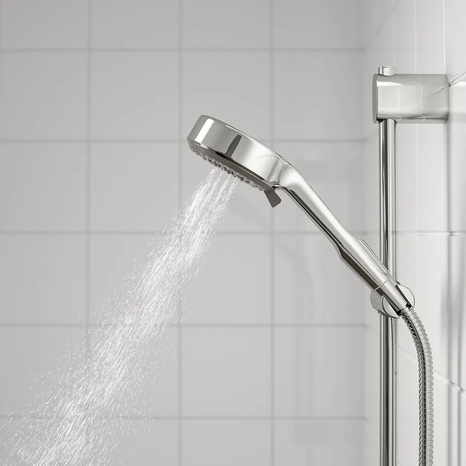 Shiny chrome shower head with water spray. Attached to vertical holder, showing full spray function.