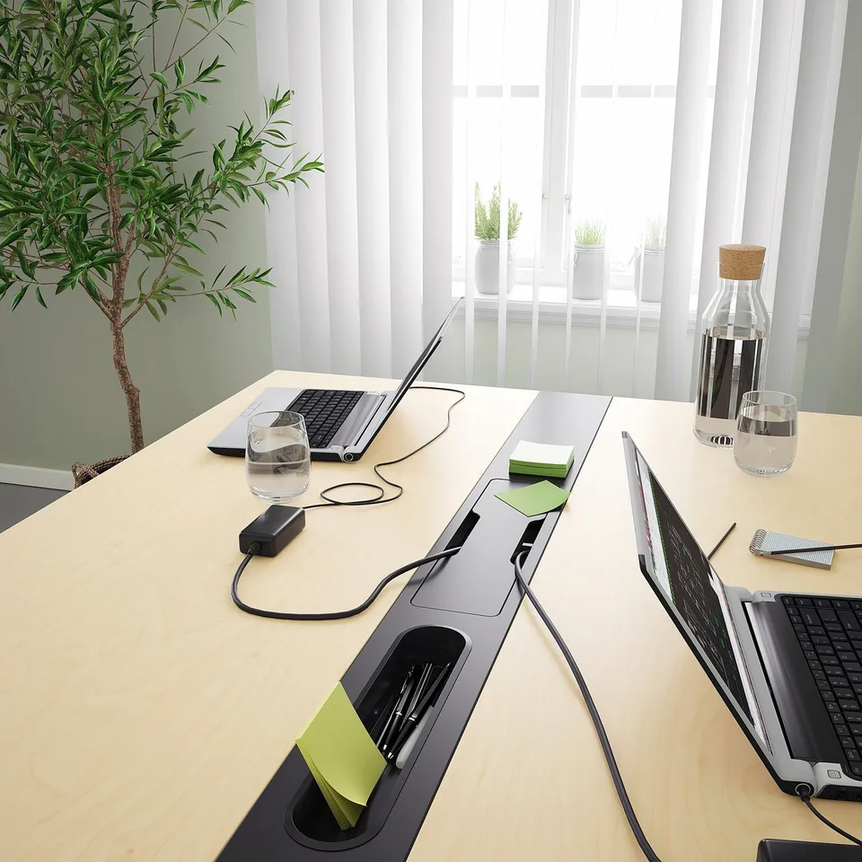 Modern conference table with integrated cable management for laptops.