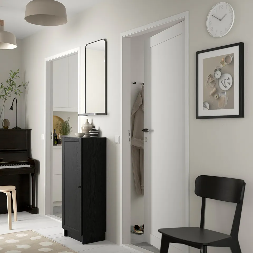 Hallway with BILLY bookcase, chair, coat rack; piano nearby; decor with clock and art.