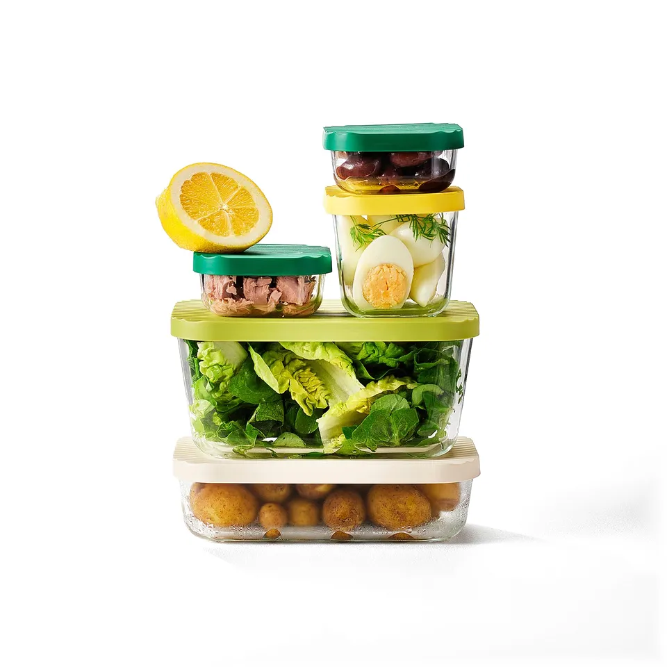 Stacked glass food containers with colourful lids hold varied meals and leftovers, saving space in kitchen storage.