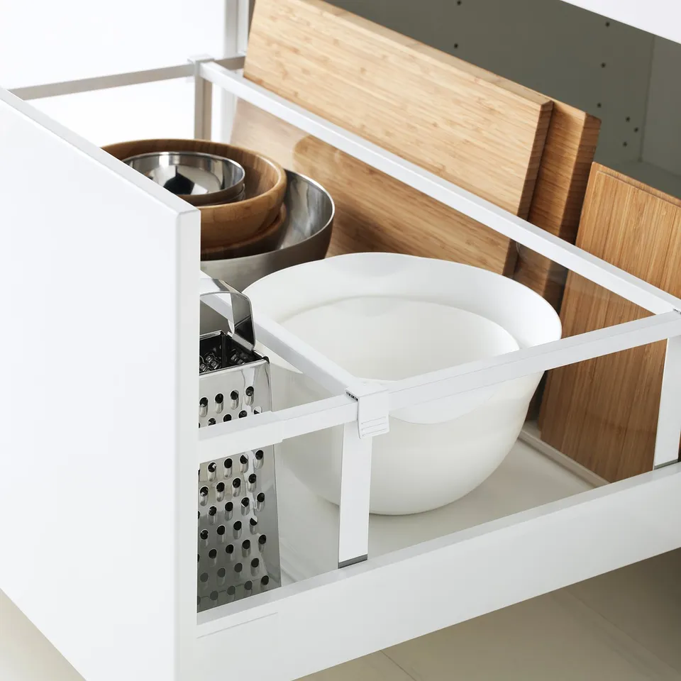 Open kitchen drawer with organised bowls and cutting boards.