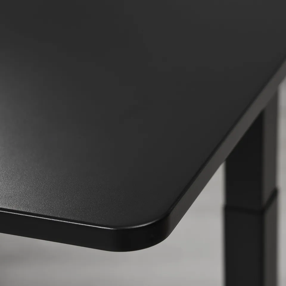 Modern gaming desk with smooth, matte black surface. Rounded edges for comfort. Reflection-free finish.
