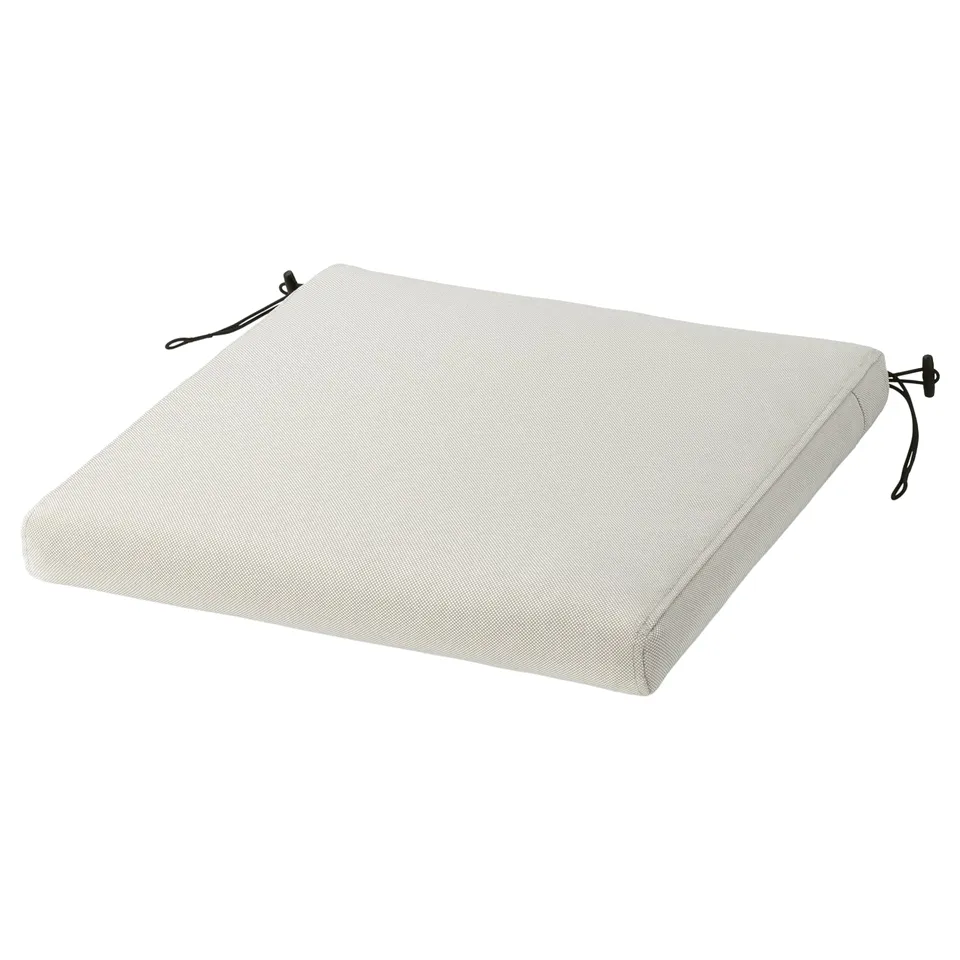Rectangular white outdoor chair cushion with black ties, made from recycled materials.