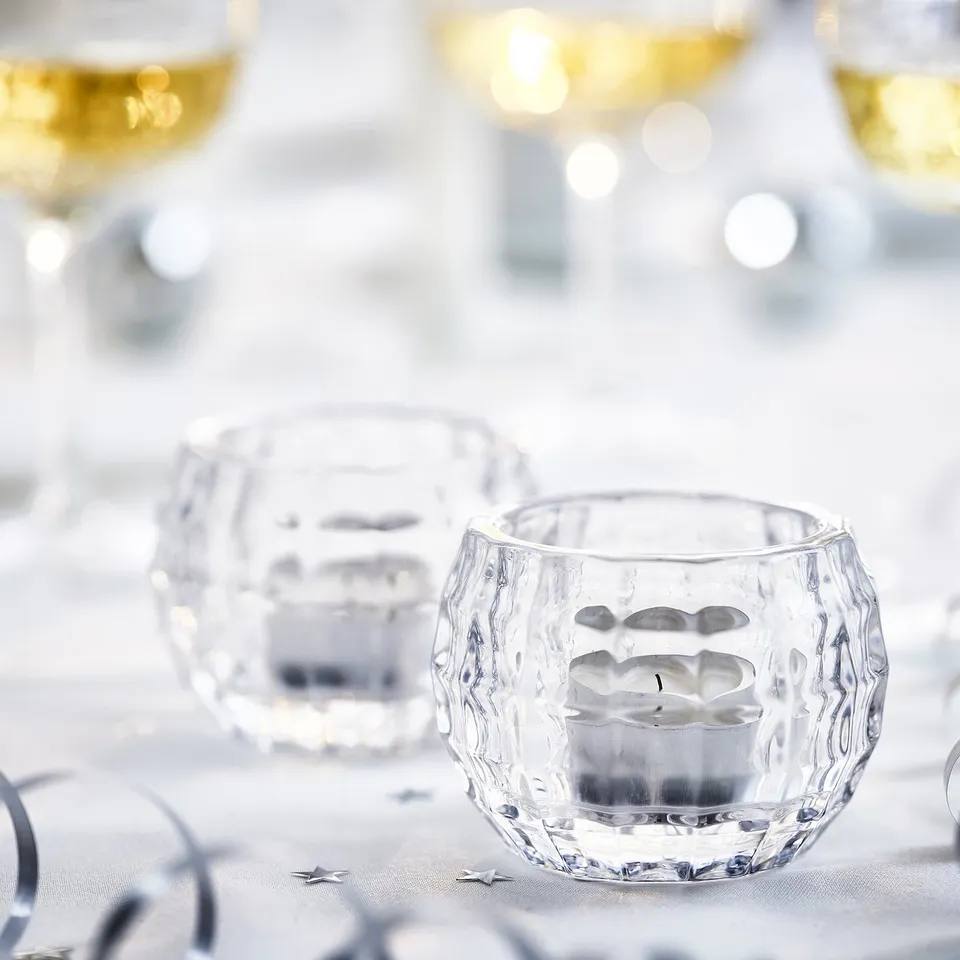 Elegant glass candle holders, textured surfaces, reflect light gently. Perfect for dining tables.