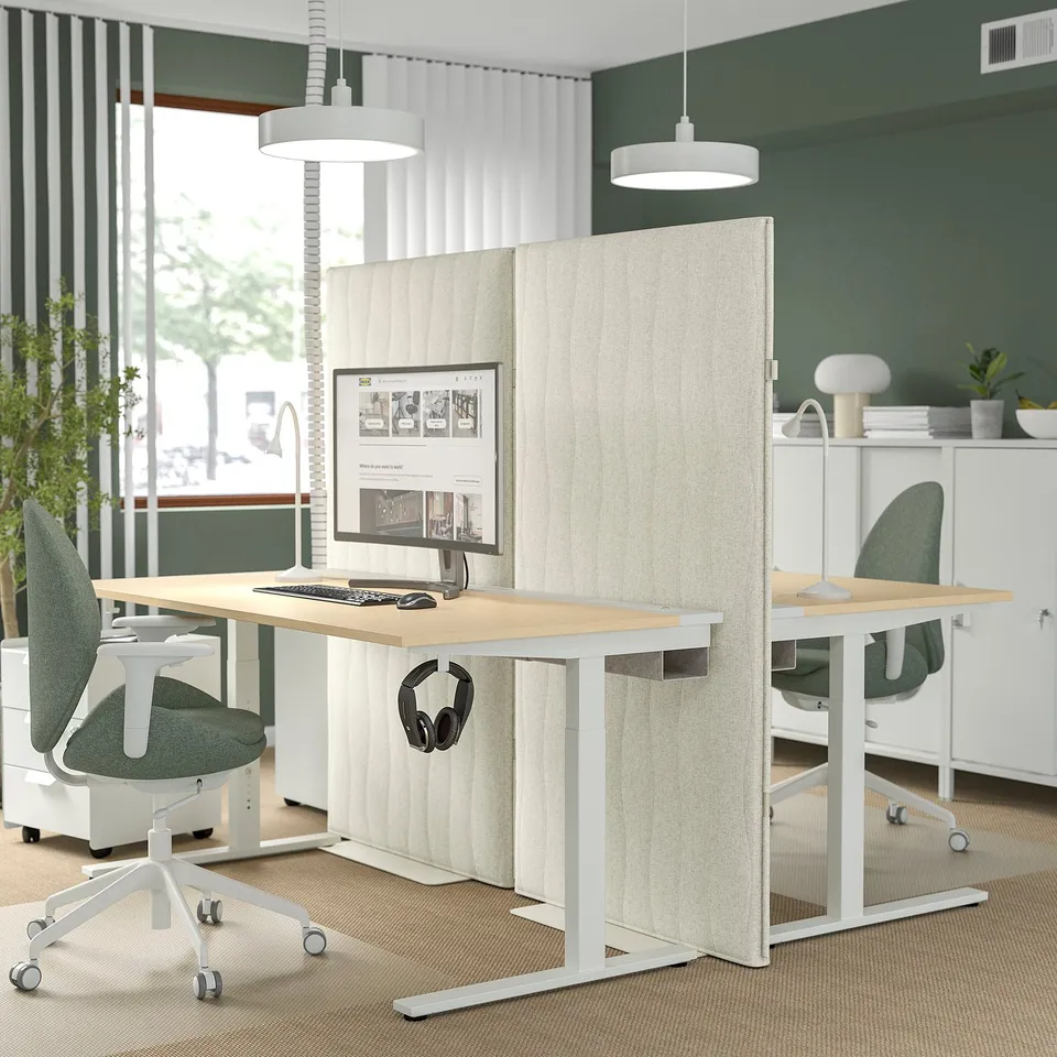 MITTZON: acoustic screen divides office space. Tall, beige, with rippled design. Surrounds dual workstations with green chairs.
