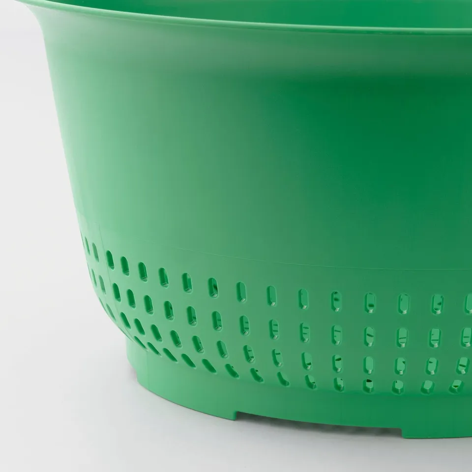 Green plastic colander with side handles; perforated for drainage.