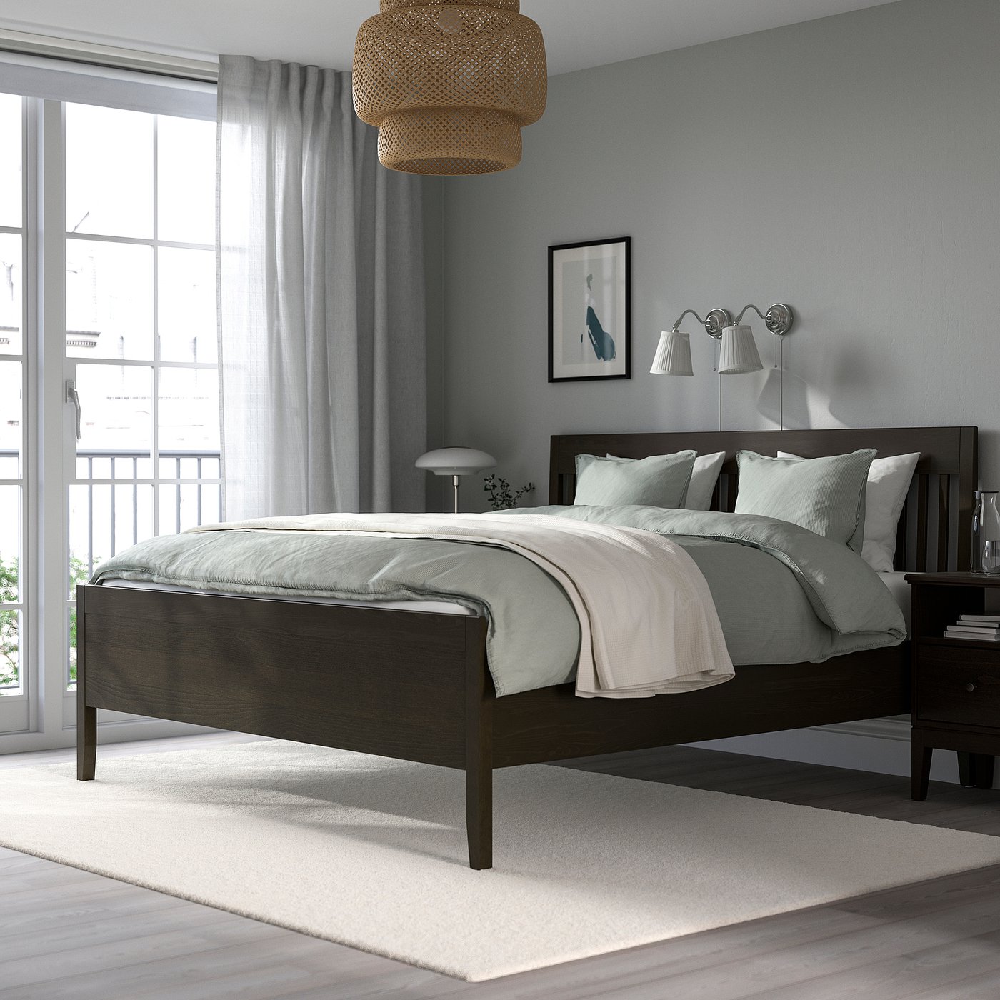 Modern bedroom with queen bed, dark wood frame, grey linens, lamps, large window, city view.