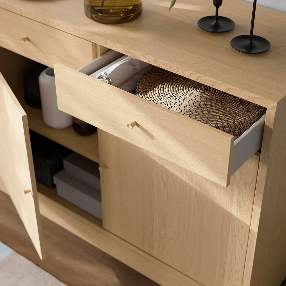 Light wooden cabinet with open drawer revealing organised items, showcasing soft-closing functionality and adjustable storage.