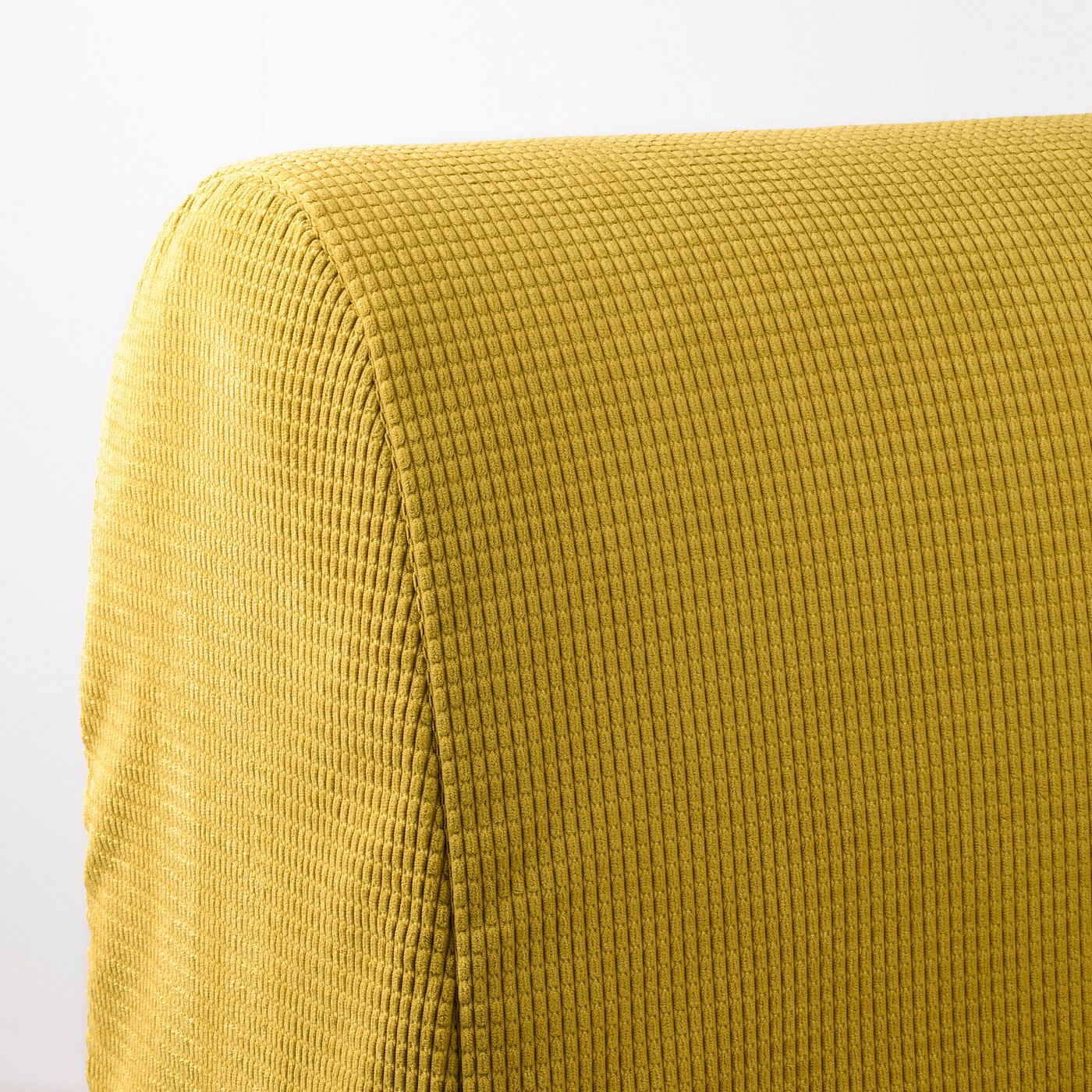 Yellow textured sofa fabric close-up. Soft, textured weave pattern visible.