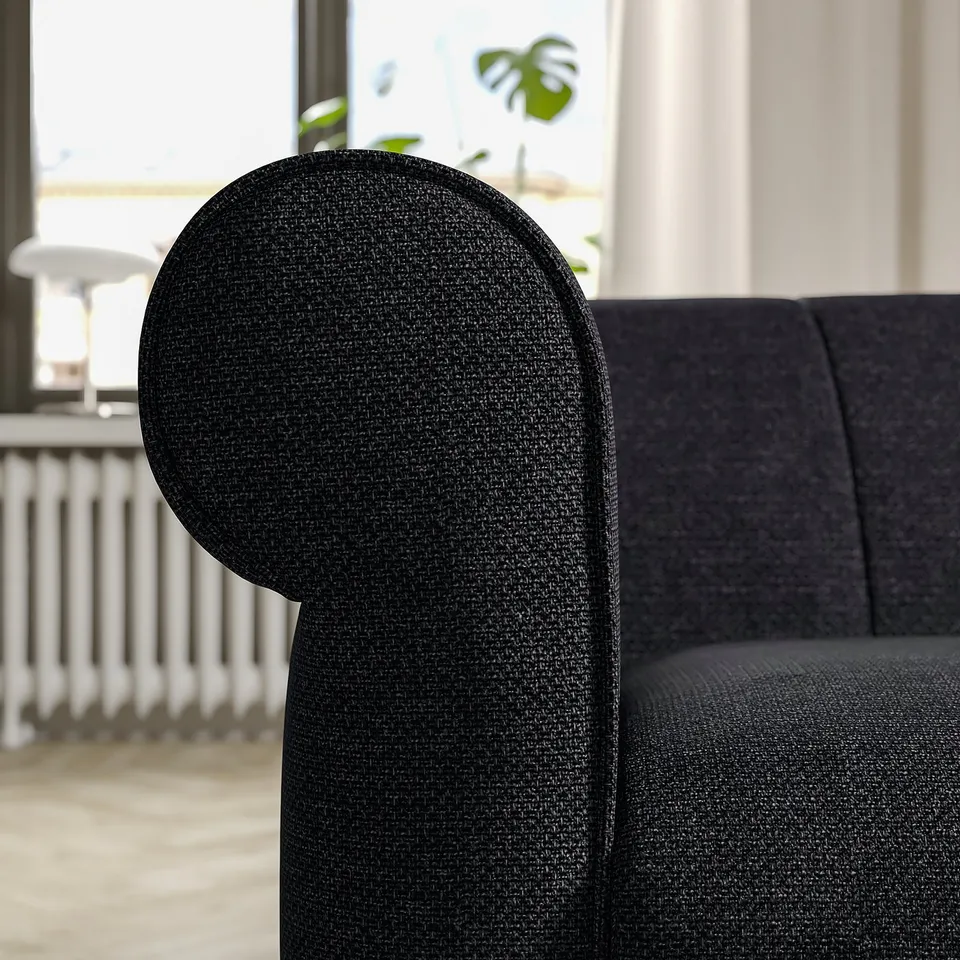 Black VISKAFORS sofa close-up: curved backrest, textured fabric, soft rounded shape.