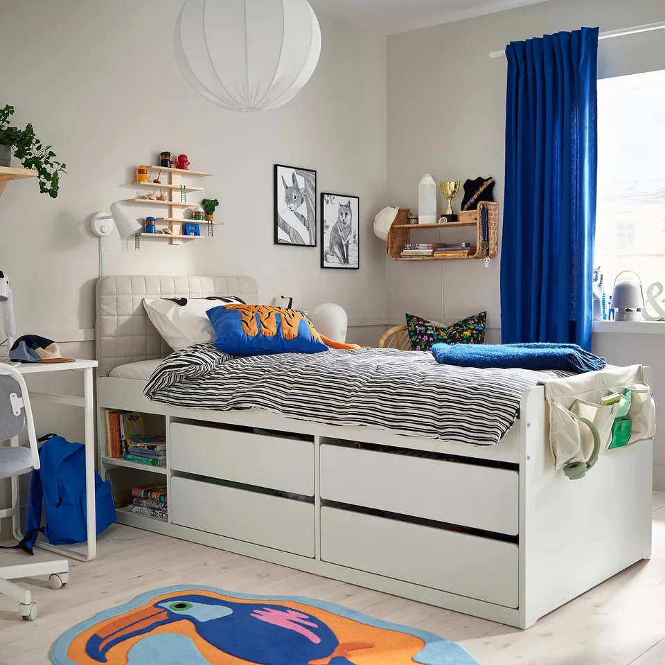 Modern kids room with SLÄKT bed, pillows, storage, headboard, curtains, desk, lamp, rug, decor.