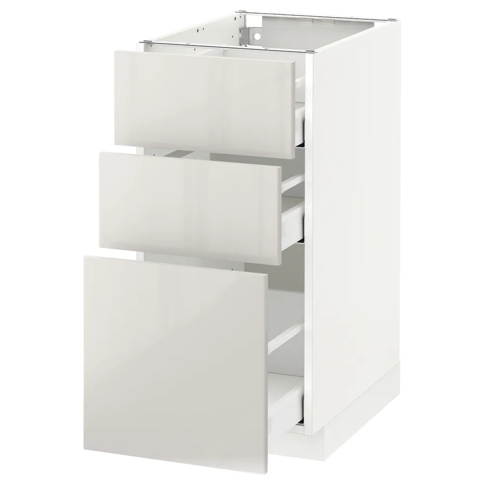 A white METOD kitchen cabinet with three open drawers, shiny high-gloss finish, and a sleek modern design.