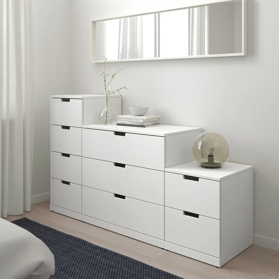 Modern white NORDLI chest with multiple drawers. Sits low, fits under a large wall mirror, tuned with decor. Safe, smooth, and versatile.