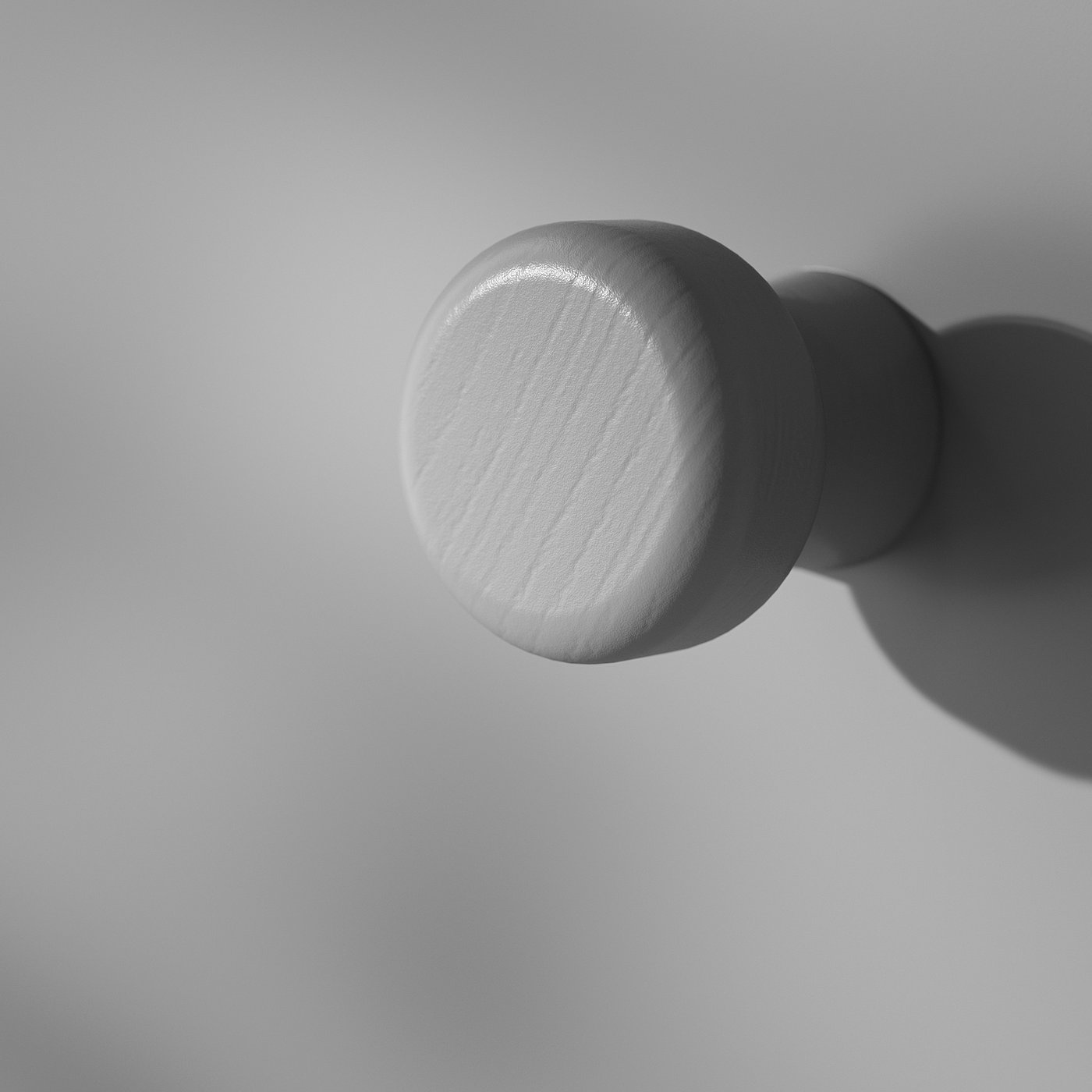 Knob detail: smooth, rounded wood, polished finish, casting subtle shadow.