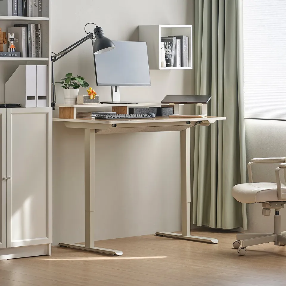 Minimalist home office with TRAVSPORT desk, cable management, top shelf, white cabinet, black lamp, and curvy chair.