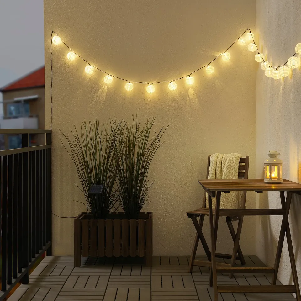 SOLARVET lights decorate balcony, adding warm glow. Lights above table create cosy atmosphere.