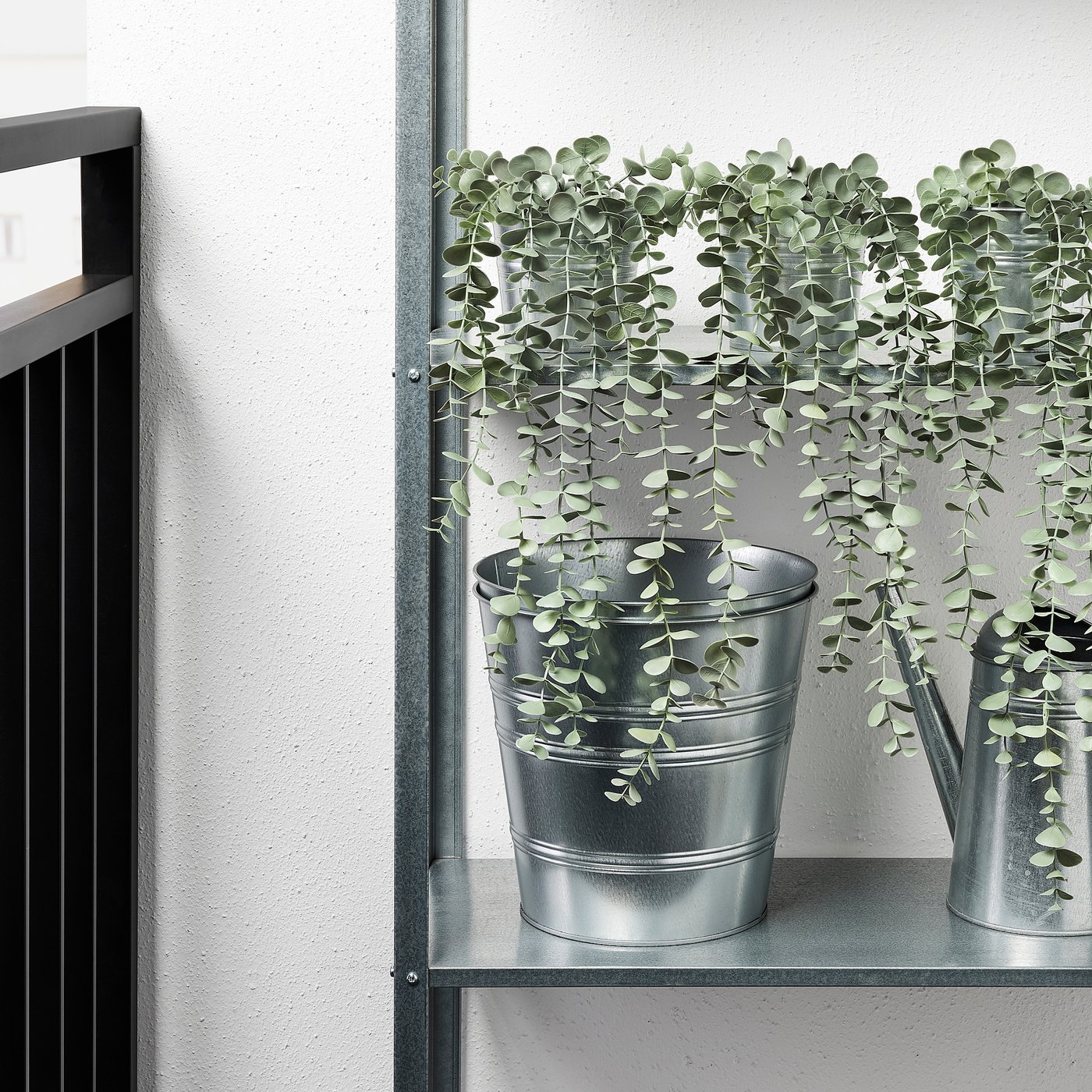 Two artificial hanging plants in galvanised metal pots on a metal shelf. Perfect for low-maintenance indoor or outdoor decor.