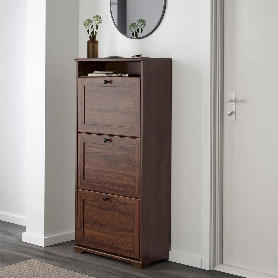 Wooden shoe cabinet, 3 compartments, holds ~15 pairs, near door, top shelf for extra storage.