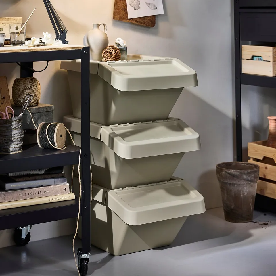 Three stacked SORTERA bins on a black cart, perfect for sorting waste or laundry. The foldable lids allow easy access even when stacked.