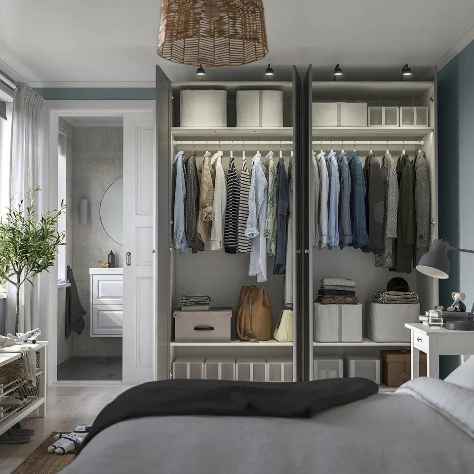 Modern wardrobe with open hanging clothes, shelves, and storage boxes. Wall-mounted, adjustable feet, and built-in lights.