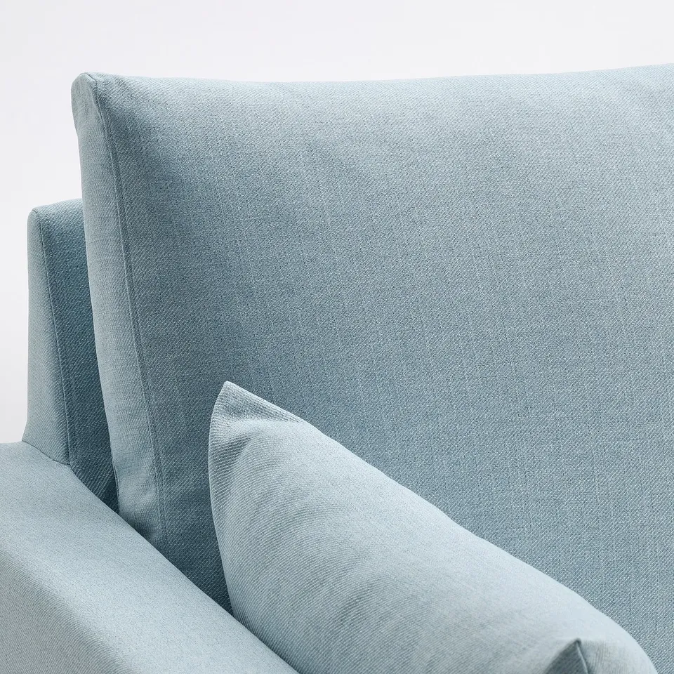 Light blue sofa corner shown, soft fabric, clean lines, inviting comfort.