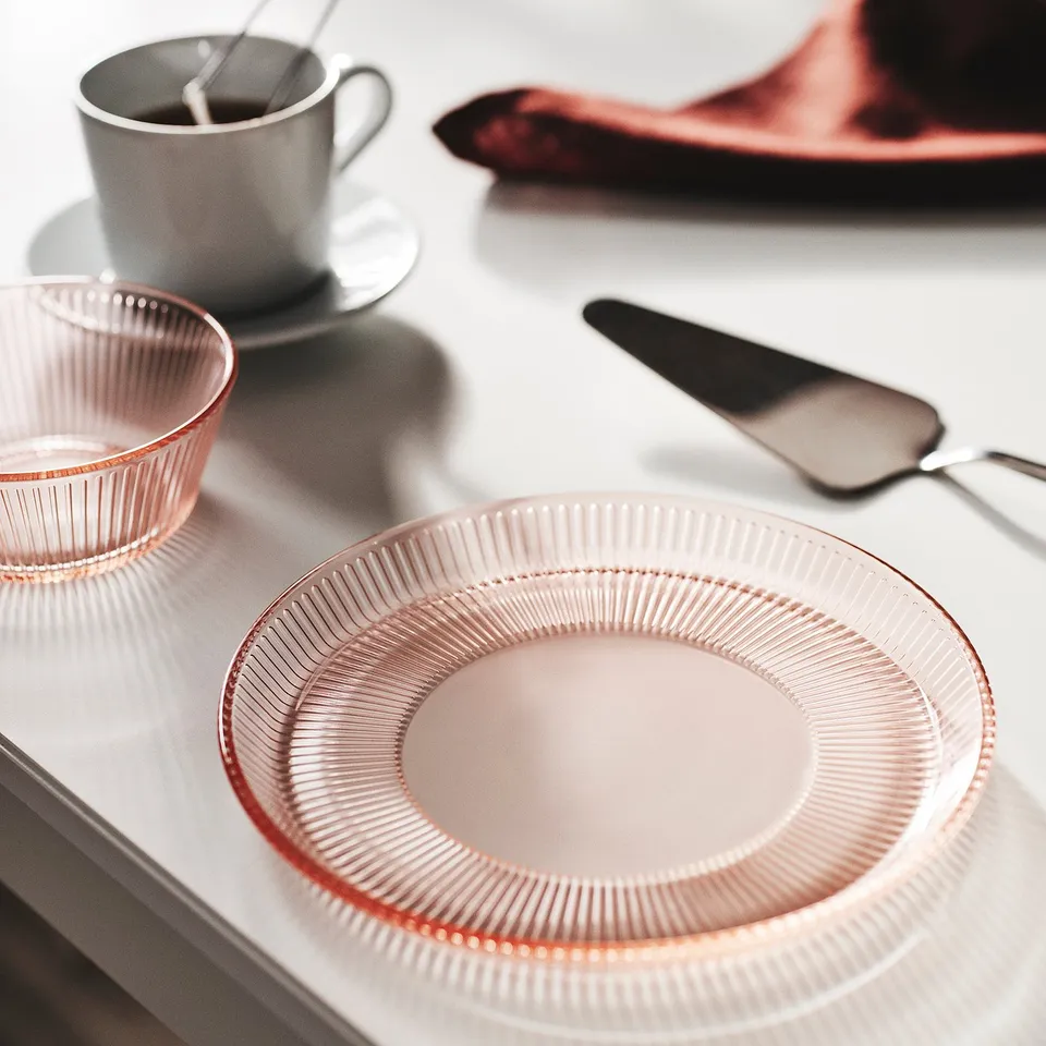 Pink glass dinnerware set: plate & bowl with ridged designs, stackable, near white mug.